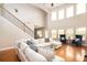 Light-filled living room with a high ceiling, large windows, hardwood floors, and a comfortable seating arrangement at 3631 Guinevere Trace Trce, Douglasville, GA 30135