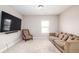 Cozy bonus room with a comfortable sofa, accent chair, large TV, and natural light from the window at 3631 Guinevere Trace Trce, Douglasville, GA 30135