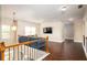 Upstairs living room with hardwood floors, a blue sofa, tv, and decorative railing with a hanging light fixture at 3631 Guinevere Trace Trce, Douglasville, GA 30135