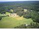 Aerial view of a property with pastures and forest at 668 Spring Place Ne Rd, White, GA 30184