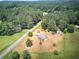 Overhead shot showcasing the home, multiple outbuildings, open land, and bordering wooded area for a private setting at 668 Spring Place Ne Rd, White, GA 30184