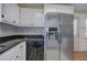 Kitchen with stainless steel refrigerator, black countertop and diamond backsplash at 668 Spring Place Ne Rd, White, GA 30184