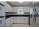 Cozy kitchen featuring white cabinets, stainless steel appliances, and a corner sink at 668 Spring Place Ne Rd, White, GA 30184