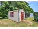 Quaint outbuilding with neutral siding, red trim, and green surroundings at 668 Spring Place Ne Rd, White, GA 30184