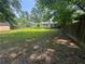 Backyard featuring a well-maintained lawn, surrounded by trees, sheds, and a wooden fence at 8249 Creekline Ct, Riverdale, GA 30274
