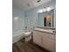 Bathroom featuring a vanity with granite countertop, a toilet, and a bathtub with tiled surround and updated fixtures at 8249 Creekline Ct, Riverdale, GA 30274