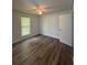Bedroom featuring hardwood floors, a ceiling fan, a window, and white walls, offering a comfortable and inviting space at 8249 Creekline Ct, Riverdale, GA 30274