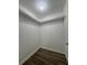 A walk-in closet boasts hardwood floors, white shelving, and a central light fixture for ample illumination at 8249 Creekline Ct, Riverdale, GA 30274