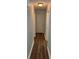 Hallway featuring hardwood flooring and neutral-colored walls, complemented by white trim and multiple doorways at 8249 Creekline Ct, Riverdale, GA 30274