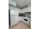 Compact kitchen featuring granite countertops, white cabinets, and essential appliances at 8249 Creekline Ct, Riverdale, GA 30274