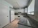 Charming kitchen featuring granite counters, tiled floors, and white cabinets and appliances at 8249 Creekline Ct, Riverdale, GA 30274