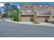 Exterior rear view of a two-story brick townhome with garage, balcony, and well-maintained landscaping at 2530 Clairebrooke Bend, Atlanta, GA 30341