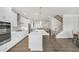 Open concept kitchen with island, stainless appliances, and view to the living room and staircase at 2530 Clairebrooke Bend, Atlanta, GA 30341