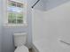 Bright bathroom featuring a white toilet, bathtub, and window with natural light streaming through blinds at 2827 Highway 138 Ne, Conyers, GA 30013
