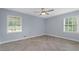 Light-filled bedroom featuring herringbone floors, two windows, and fresh paint at 2827 Highway 138 Ne, Conyers, GA 30013
