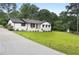 One-story home with a freshly sealed driveway and inviting landscape at 2827 Highway 138 Ne, Conyers, GA 30013