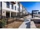 Street view of modern townhomes featuring brick accents, iron fencing, and manicured landscaping at 350 Olmstead Way # 29, Alpharetta, GA 30022