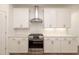 Bright kitchen features stainless steel oven and vent hood, white cabinets, and patterned backsplash at 350 Olmstead Way # 29, Alpharetta, GA 30022