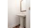 Powder room featuring pedestal sink, mirror, and hardwood floors at 350 Olmstead Way # 29, Alpharetta, GA 30022