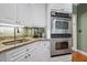 Close up on the kitchen features a stainless steel oven, granite countertops and white cabinets at 1488 Lachona Ne Ct, Atlanta, GA 30329