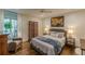 Comfortable bedroom features a decorative screen, large bed, accent chair and view of a landscaped yard at 1757 E Clifton Ne Rd, Atlanta, GA 30307