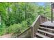 Wooden staircase leads to a tranquil deck surrounded by lush greenery and mature trees at 1757 E Clifton Ne Rd, Atlanta, GA 30307