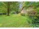 Expansive backyard featuring lush green grass, mature trees, and natural landscaping at 267 Firecreek Rdg, Lawrenceville, GA 30046