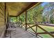 Inviting front porch with wood flooring, exposed beam ceiling, and decorative wood railing at 267 Firecreek Rdg, Lawrenceville, GA 30046