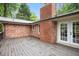 Wood deck with brick chimney and brick exterior with double doors leading to interior at 2695 Peeler Rd, Dunwoody, GA 30360