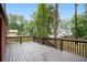 Spacious wood deck overlooking a large backyard with mature trees and distant view of a home at 2695 Peeler Rd, Dunwoody, GA 30360