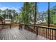 Spacious wood deck overlooking a large backyard with mature trees and distant view of a home at 2695 Peeler Rd, Dunwoody, GA 30360