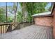 Wood deck next to the brick exterior of the home and the wooded back yard at 2695 Peeler Rd, Dunwoody, GA 30360
