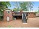 Exterior of brick home featuring wood deck with stairs leading to the backyard with mature trees at 2695 Peeler Rd, Dunwoody, GA 30360