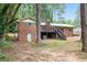 Exterior of brick home featuring wood deck with stairs leading to the backyard with mature trees at 2695 Peeler Rd, Dunwoody, GA 30360