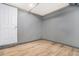 Small finished room in basement with gray walls and wood-look tile flooring and a white door at 2695 Peeler Rd, Dunwoody, GA 30360