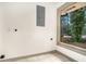 Unfinished basement area with tile flooring, a window and connections for a washer and dryer at 2695 Peeler Rd, Dunwoody, GA 30360