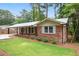 Inviting brick home with a covered carport, shutters, and a lush green lawn at 2695 Peeler Rd, Dunwoody, GA 30360