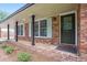 Welcoming front porch showcasing brick detail, black columns, and stylish front door at 2695 Peeler Rd, Dunwoody, GA 30360