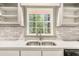 Bright kitchen with double sinks, white subway tile, and view of the backyard at 2695 Peeler Rd, Dunwoody, GA 30360