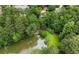 Aerial view of the property showcasing a lake, pool, rock waterfall, and surrounding greenery at 5065 Nesbit Ferry Ln, Atlanta, GA 30350