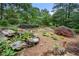 Picturesque landscaped backyard featuring a rock pond and well-manicured flower beds at 5065 Nesbit Ferry Ln, Atlanta, GA 30350