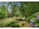 Picturesque view of the backyard and lake, featuring hydrangeas, benches, and a fountain at 5065 Nesbit Ferry Ln, Atlanta, GA 30350