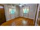 Cozy bedroom featuring hardwood floors, patterned wallpaper, and two windows at 5508 Zanola Sw Dr, Mableton, GA 30126