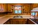 A view of the kitchen sink and countertop with knotty pine cabinets above and below at 5508 Zanola Sw Dr, Mableton, GA 30126