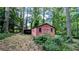 Outbuilding featuring a driveway canopy, mature trees, and green grass at 5508 Zanola Sw Dr, Mableton, GA 30126