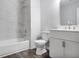 Updated bathroom with marble tile shower, toilet, vanity and wood-look flooring at 5380 Bridle Point Pkwy, Snellville, GA 30039