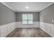 Dining room featuring wainscoting, hardwood flooring, and a bright window at 5380 Bridle Point Pkwy, Snellville, GA 30039