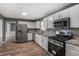 Spacious kitchen with stainless steel appliances, granite countertops, and a view of the dining area at 5380 Bridle Point Pkwy, Snellville, GA 30039
