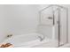 A luxurious white soaking tub and glass-enclosed shower for a spa-like experience at 625 Piedmont Ne Ave # 105, Atlanta, GA 30308
