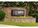 Elegant community sign with brick facade, stone accents, and lush landscaping at 'Harper on Piedmont' at 625 Piedmont Ne Ave # 105, Atlanta, GA 30308